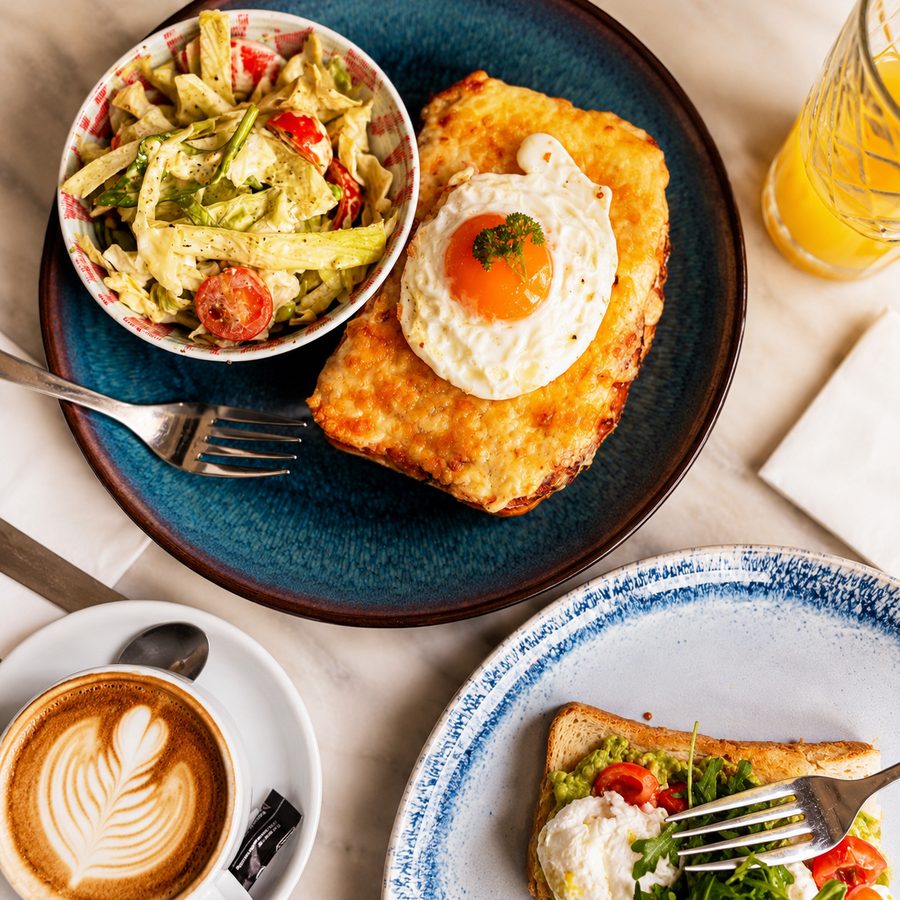 Croque monsieur with a topped egg and a cappuccino